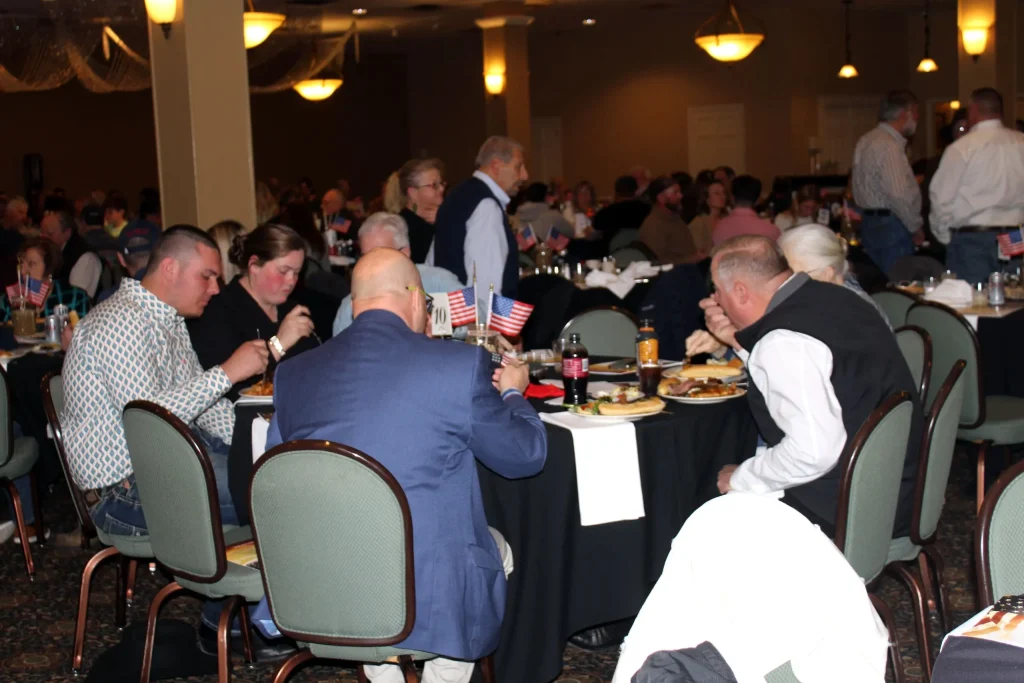 Members seated at dinner tables at the Night of the Hunter fundraiser